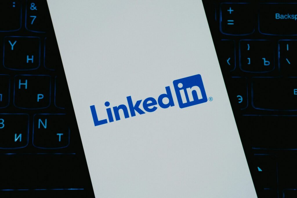 Close-up of LinkedIn logo on smartphone screen, with keyboard background.